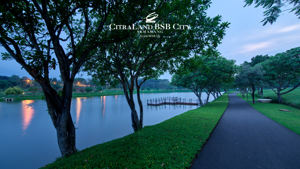 Danau yang tenang di CitraLand BSB City, Semarang, dengan jalan setapak di tepi danau dan pepohonan rindang di sekitarnya.